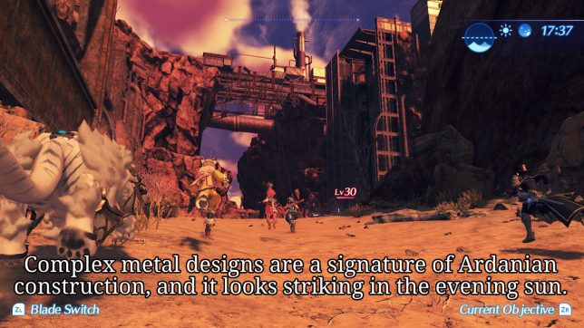 Image: A sunset-lit red cliff lined with dark metal scaffolding and pipes.
Text: Complex metal designs are a signature of Ardanian construction, and it looks striking in the evening sun.
